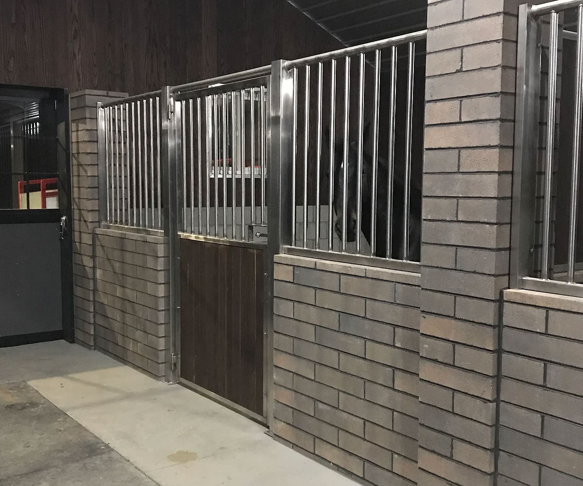 Horse stall with brick and metal combination, for a clean rustic look.