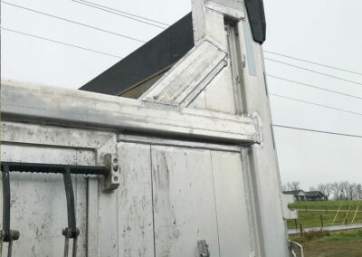 Close view of the back of a 3 axle dump truck showing repairs on the dump box