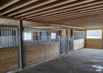 Wood and metal horse gates inside wood barn