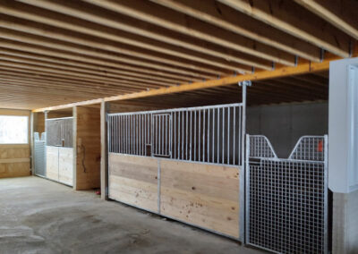 Several horse gates inside a wooden barn