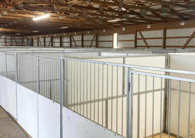 Large building with rows of Portable horse stalls set up.