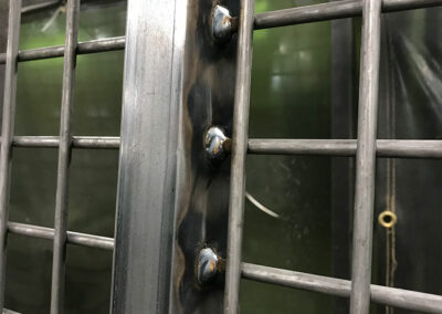 Close up view of a welding job on a horse gate.