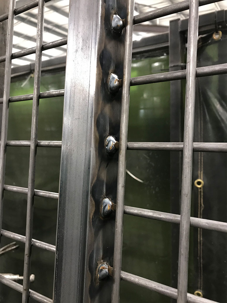 Close up view of a welding job on a horse gate.