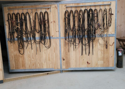 Custom pivoting barn door with a custom built rack for reins