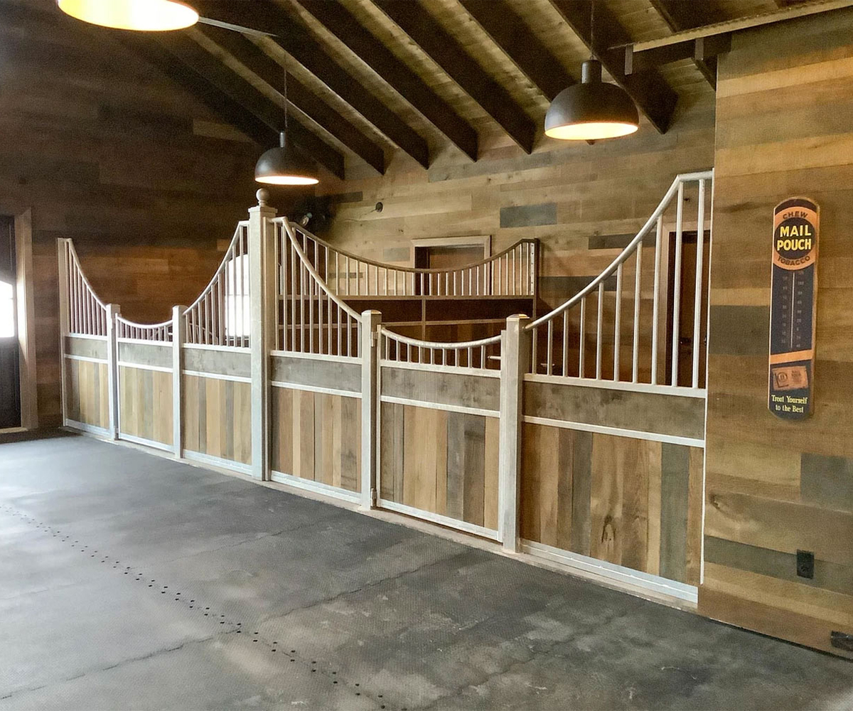 Custom horse stall fencing and gate panels inside a barn